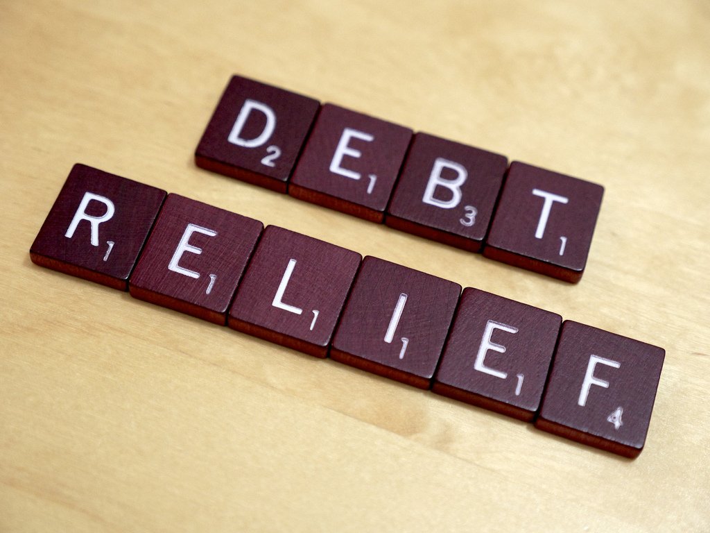 letters on small tiles that spell out the words "Debt Relief)