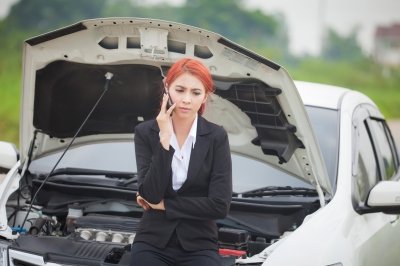Young woman with broken down car
