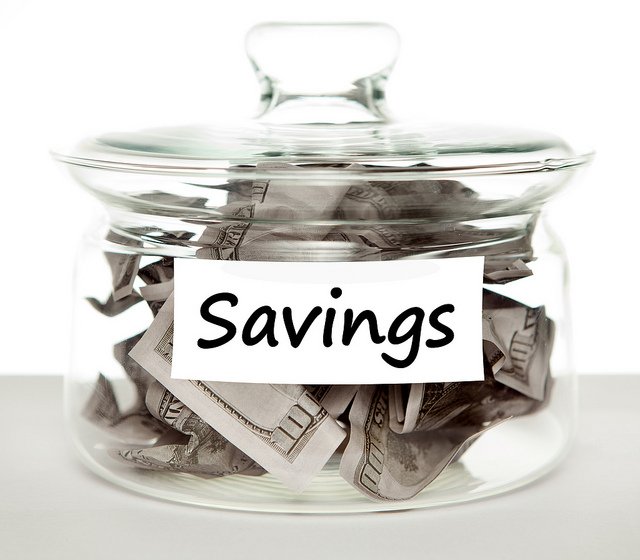 savings jar with $100 bills 